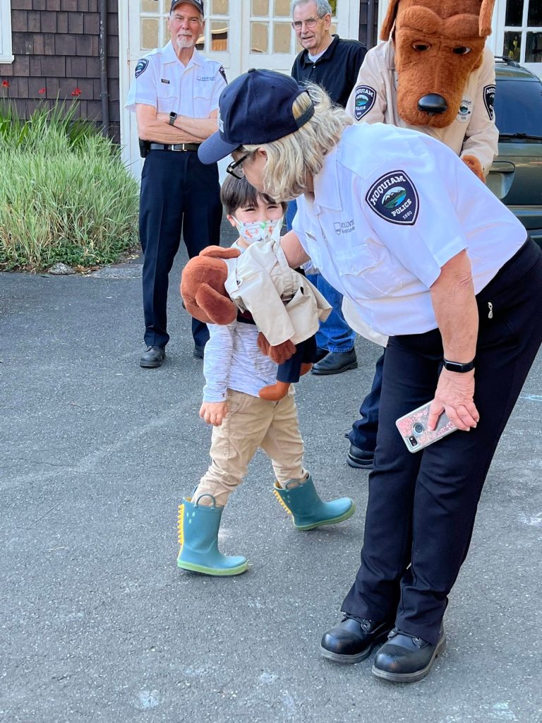 Betsy Seidel, Hoquiam Police Crime Watch coordinator, has McGruff the Crime Dog Jr., give a kiss to one of the many children at National Night Out on Tuesday, Aug. 2, 2022, at Polson Museum. Seidel would greet people with a shake that was more of a light bite from the crime fighting puppy. (Matthew N. Wells | The Daily World)