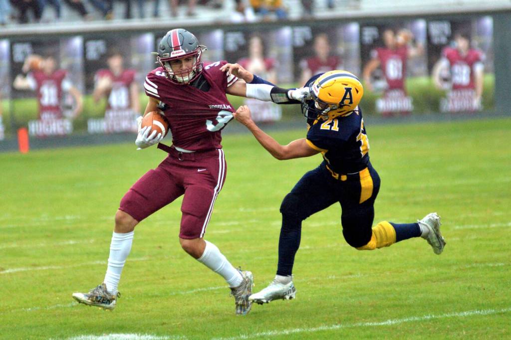 RYAN SPARKS | THE DAILY WORLD Hoquiam receiver Owen McNeill, left, gets his hand caught in the facemask of Aberdeen defender Trey Anderson during Aberdeens 40-0 victory on Friday in Hoquiam. The two teams combined for 20 penalties in the season-opening game.