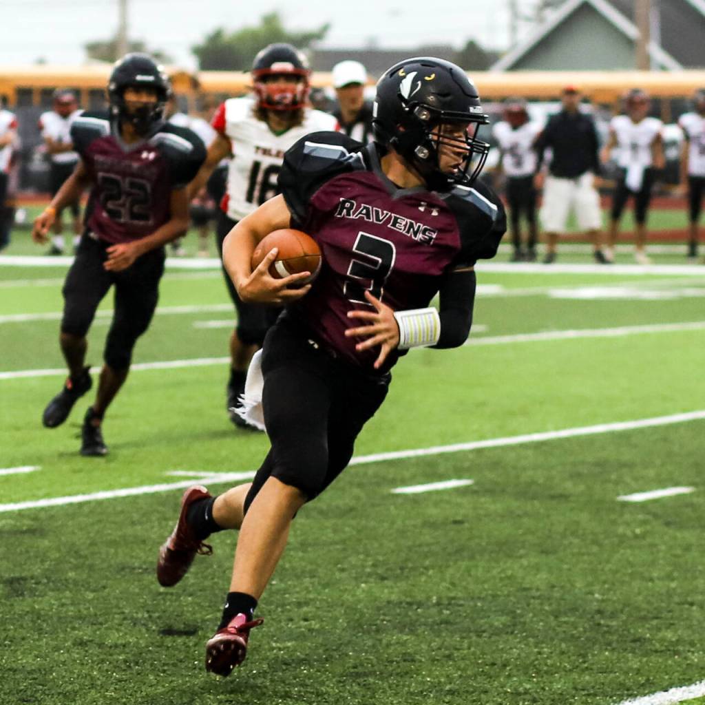 PHOTO BY LARRY BALE Raymond-South Bend quarterback Austin Snodgrass carries the ball during the Ravens 35-20 victory over Toledo on Friday in South Bend. Snodgrass ran for 143 yards and three touchdowns in the win.