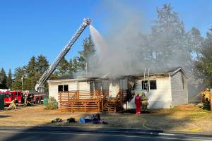 Personnel from the South Beach Regional Fire Authority work to extinguish a residential fire in Westport on Sept. 19, 2022. (Michael S. Lockett / The Daily World)