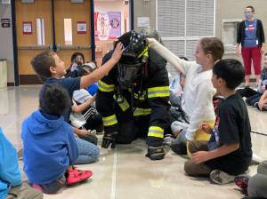 Michael S. Lockett | The Daily World
Firefighter/EMT James Freed crawls in full kit through a group of second graders at McDermoth Elementary School during a Fire Prevention Week presentation from the Aberdeen Fire Department on Monday.