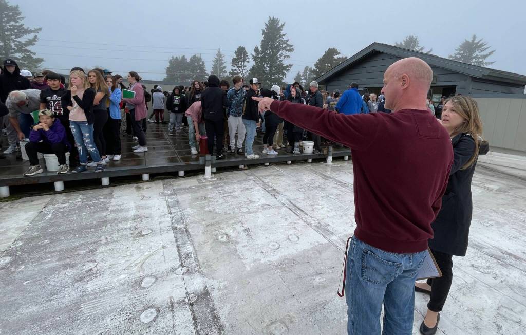 Principal of Ocosta Junior- Senior High School Michael Cummings, pointing, takes accountability for the school as he talks to the principal of Ocosta Elementary School, Holly Samuelson, right of him, during the Great ShakeOut, a statewide tsunami evacuation drill on Oct. 20. (Michael S. Lockett / The Daily World)