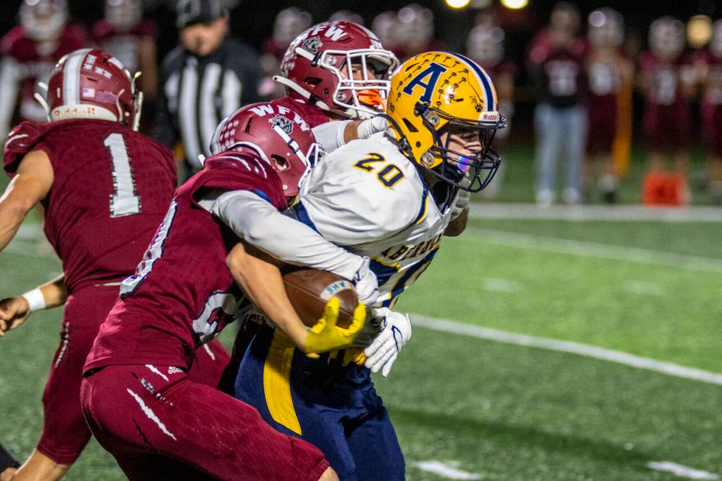 PHOTO BY ERIC TRENT Aberdeen running back Jeremy Sawyer (20) drags a WF West defender during the Bobcats 42-15 loss on Thursday in South Bend.