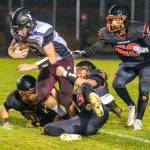 JARED WENZELBURGER | THE CHRONICLE Napvine players swarm and make a tackle on Raymond-South Bends Austin Snodgrass after blocking a punt during the Ravens 54-0 loss Friday, in Napavine.