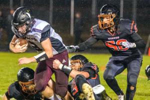 JARED WENZELBURGER | THE CHRONICLE
Tigers swarm and make a tackle after blocking a punt during a league championship game against Raymond-South Bend Friday night.
