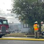 Firefighters confer during the tail end of a response to a fire in Hoquiam on Thursday. (Michael S. Lockett / The Daily World)