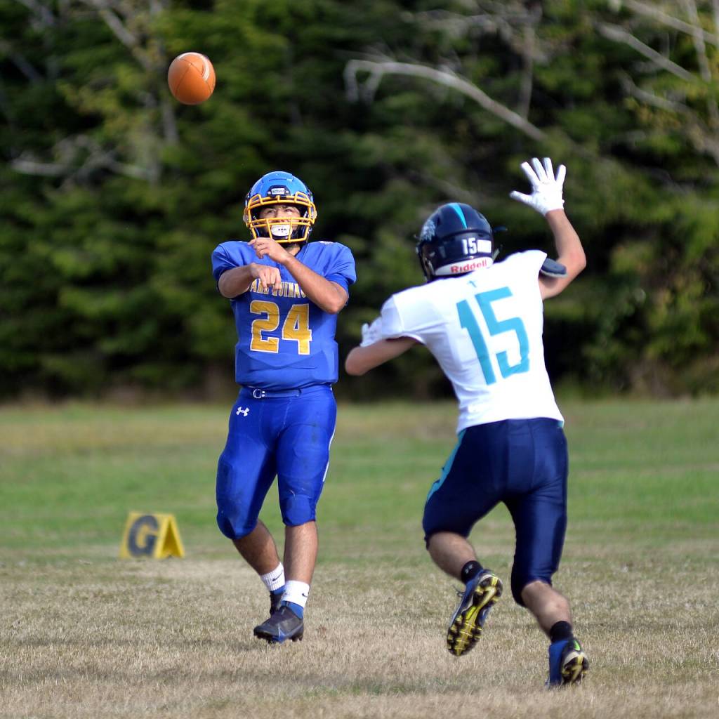 RYAN SPARKS | THE DAILY WORLD Lake Quinault quarterback Jesse Ferry (24) throws a pass while Northwest Christians Carter Sands defends during the Elks 67-38 win on Saturday, Oct. 29, 2022 at Lake Quinault High School.