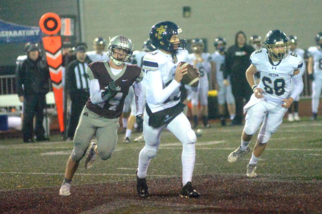 RYAN SPARKS / THE DAILY WORLD 
Montesano defensive lineman Tyler Johansen, left, chases Seton Catholic quarterback Kolten Gesser during the Bulldogs 47-7 win over Seton Catholic in a 1A district crossover game on Friday, Nov. 4, in Montesano.