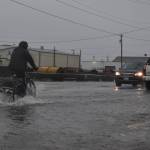 Clayton Franke / The Daily World
A biker rides through several inches of water on State Street in Aberdeen.
