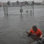 Clayton Franke / The Daily World
Kaprie Mong wades through stormwater that filled Franklin Field on Friday. The field functions as a stormwater retention facility. Mong said she swam in the field for fun.