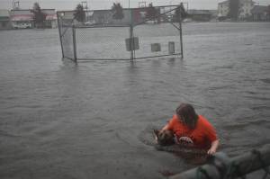 Clayton Franke / The Daily World
Kaprie Mong wades through stormwater that filled Franklin Field on Friday. The field functions as a stormwater retention facility. Mong said she swam in the field for fun.