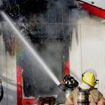 Michael S. Lockett / The Daily World 
Firefighters spray down a structure fire in Elma on Nov. 15.