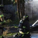 Firefighters spray down a structure fire in Elma on Nov. 15. (Michael S. Lockett / The Daily World)