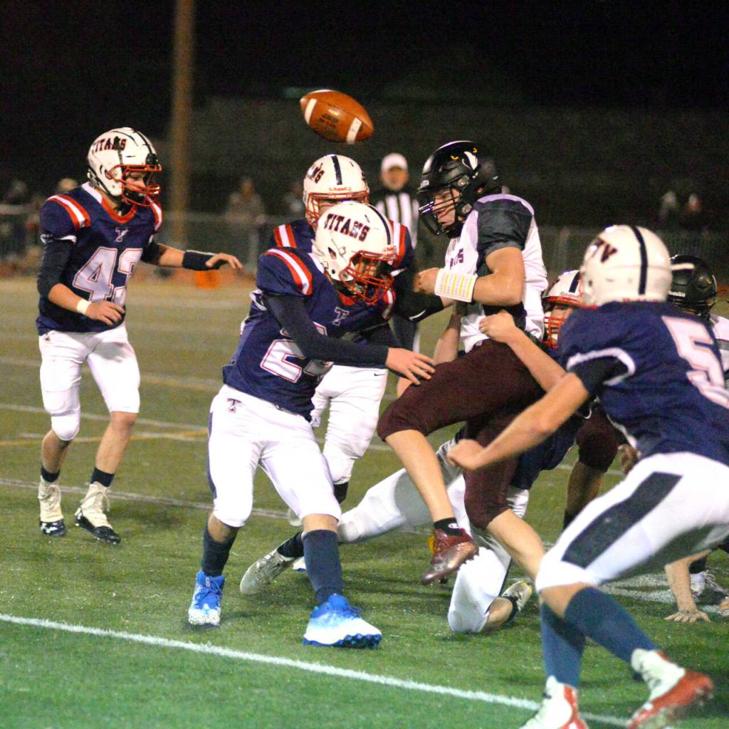RYAN SPARKS | THE DAILY WORLD Derek Fluke (24) and the Pe Ell-Willapa Valley defense knocks the ball loose from Raymond-South Bend quarterback Austin Snodgrass during the Titans 34-13 win in a 2B State quarterfinal game on Friday in Montesano.
