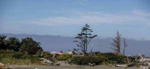 Sylvia Jarrus / The Seattle Times 
A man sits near the water at the Quinault Indian Nation in Taholah in August 2021. Climate change and rising sea levels are forcing the tribe to move homes and other buildings uphill. The Biden administration on Wednesday announced the tribe will receive $25 million in relocation funds.