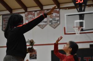 Evie Wentworth, Taholah Chitwins middle school girls basketball team manager, reaches to high-five Ruthie Bolton Wednesday night. (Clayton Franke / The Daily World)