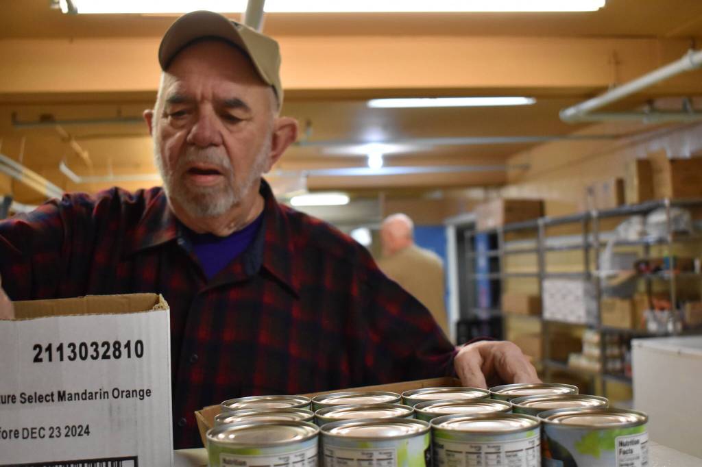 Clayton Franke / The Daily World 
Mike Barkstrom, volunteer at the Salvation Army food pantry in Aberdeen, stocks shelves Dec. 15.