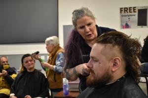 Clayton Franke / The Daily World 
Rose Warne, second from left, and her husband, Skyler Warne, front right, receive haircuts from Pat Gordon and Laina Caldwell, respectively, at the Project Homeless Connect Event on Thursday, Jan. 26 at the Aberdeen Senior Center.
