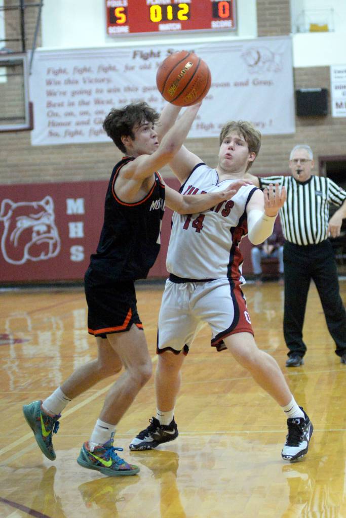 RYAN SPARKS | THE DAILY WORLD Ocostas Kayden Turner (14) attempts a pass while defended by Rainiers Jake Meldrum during the Wildcats 64-62 loss in the first round of the 2B District 4 Tournament on Saturday at Montesano High School.