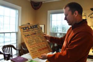 John Larson, Polson Museum's director, holds a Splash Festival poster from 1938. The poster is one of many items of Grays Harbor history that people might find interesting. While the museum is not open for tours until April, Larson and his staff are working hard to make sure it's in the best shape for a public open house April 1. (Matthew N. Wells / The Daily World)