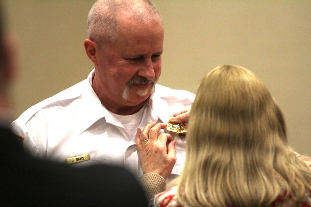 Volunteer Assistant Chief George Foster of the Ocean Shores Fire Department is pinned by his wife Paula during a promotion ceremony on Feb. 13. (Michael S. Lockett / The Daily World)