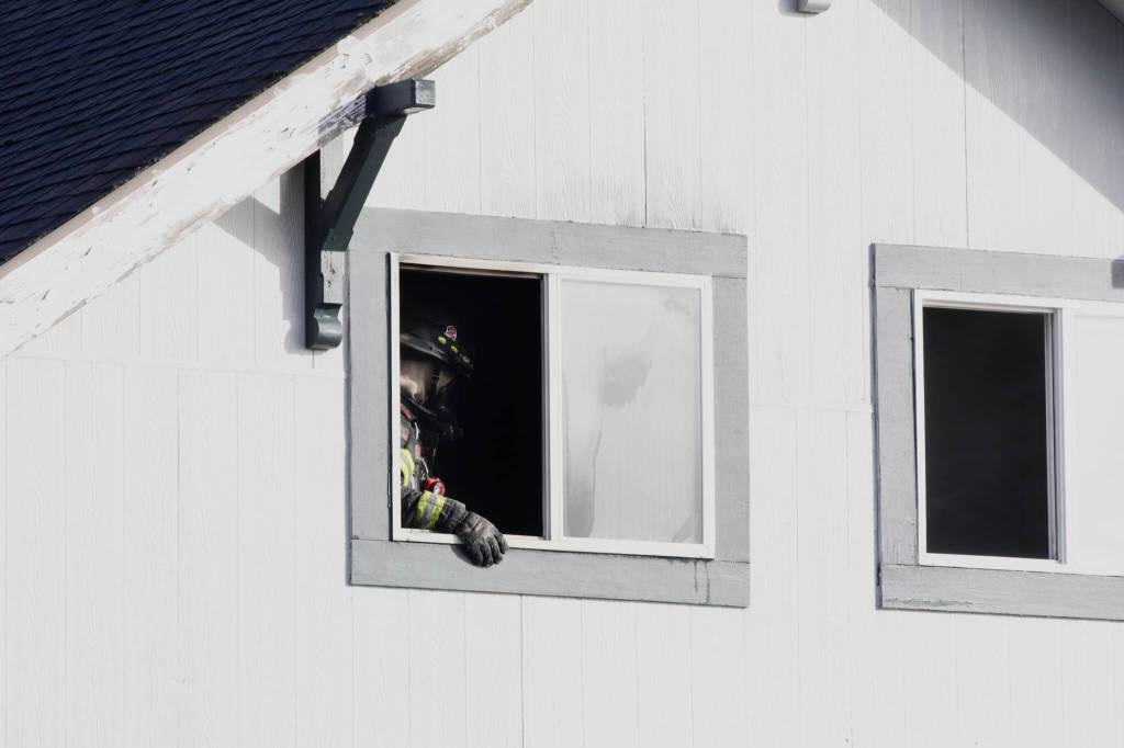 A firefighter checks out the upstairs of a two-story home in Hoquiam ravaged by fire on Feb. 17. (Michael S. Lockett / The Daily World)