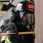 Volunteer firefighter Kori Goudey of the Montesano Fire Department practices breaching through a vertical wall with an axe during a firefighter academy in Westport on Feb. 18.