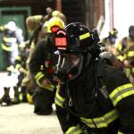 Volunteers taking part in a firefighter academy in Westport throw on their gear after lunch on Feb. 18. (Michael S. Lockett / The Daily World)