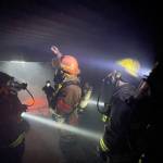 Chief Dennis Benn of the South Beach Regional Fire Authority, hand raised, demonstrates thermal layering from fire in an enclosed space during a firefighter academy in Westport on Feb. 18. (Michael S. Lockett / The Daily World)