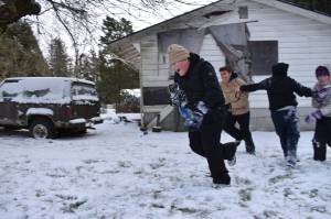 Clayton Franke / The Daily World
From left: Eli Gil, Isaac Gil, Mason Stover and Ferdanda Gil play a game of football in the snow on Thursday, Feb. 23.