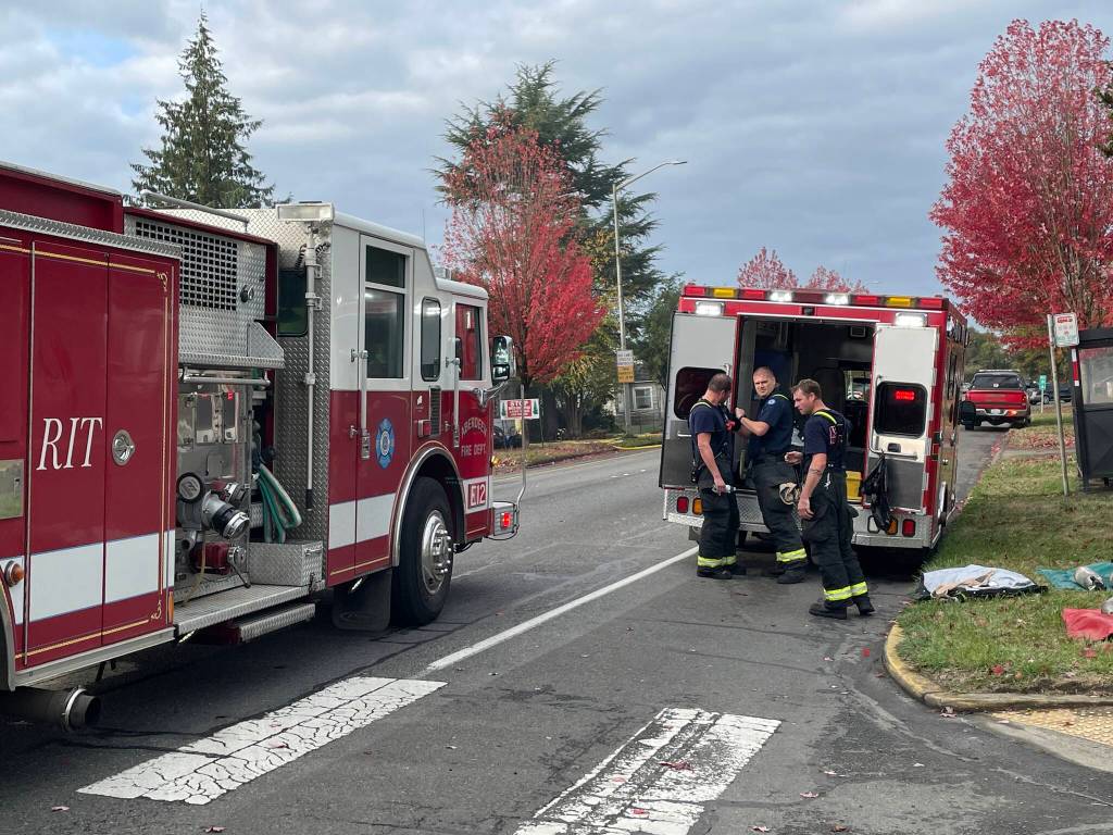 Firefighters strip off their gear after responding to a residential structure fire in Hoquiam on Thursday, Oct. 27, 2022. (Michael S. Lockett / The Daily World)