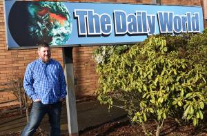 Matthew N. Wells / The Daily World
Terry Ward, the publisher for The Daily World, announced Wednesday morning that Doug Ames  pictured  is the newspapers new interim general sales manager. Ames stands in front of The Daily World sign that he himself installed a couple months ago.