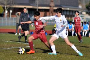 RYAN SPARKS | THE DAILY WORLD 
Hoquiam's Kunanon Chaiyakam (14) and Aberdeen's Giovanni Ambrogiani compete for possession during the Bobcats' 10-0 win on Wednesday at Sea Breeze Oval in Hoquiam.