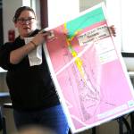 Ocean Shores Elementary School teacher Haley Stoney holds the inundation map of Ocean Shores during a school board meeting on March 21. The construction of a tsunami tower for the low-lying school has proved contentious with the public. (Michael S. Lockett / The Daily World)