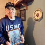 Michael S. Lockett / The Daily World
Jim Evans, one of the Chosin Few, poses in his residence with a picture of Marine Corps legend Chesty Puller.