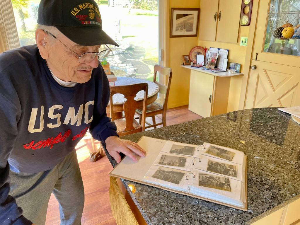 Jim Evans, a Marine veteran of Korea and one of the Chosin Few, looks at photos and news clippings from his time at war. (Michael S. Lockett / The Daily World)