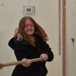 Kim Gilbert, Aberdeen Salvation Army Service Center Coordinator, takes a ceremonial swing at a wall slated for remodel inside the Salvation Army G Street church. Construction will finish by late July, Gilbert said, and the food bank and service center will relocate after that. (Clayton Franke / The Daily World)