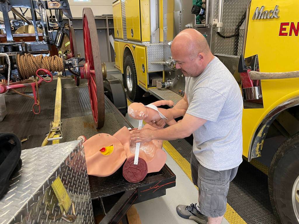 David Schrier, senior instructor for the countys EMT academy readies the birth simulator mannequin for the next scenario during the EMT academy.