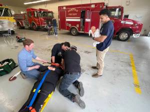 Camilo Tobito, a volunteer with the Cosmopolis Fire Department, holds the baby mannequin after a simulated birth during the EMT academy, held at the Cosmopolis on April 22. Photo: Michael S. Lockett