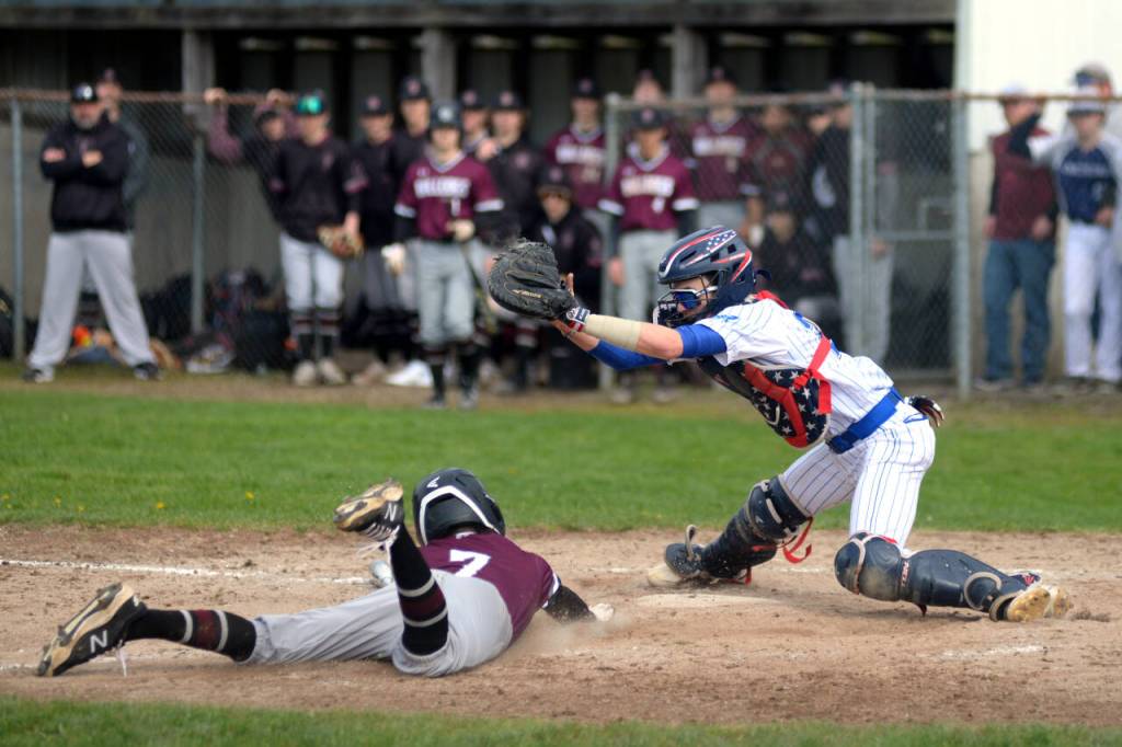 RYAN SPARKS | THE DAILY WORLD Montesano pinch runner Zach Timmons slides in safely ahead of the tag of Elma catcher Ethan Camus during the Bulldogs 11-5 victory on Monday in Elma.