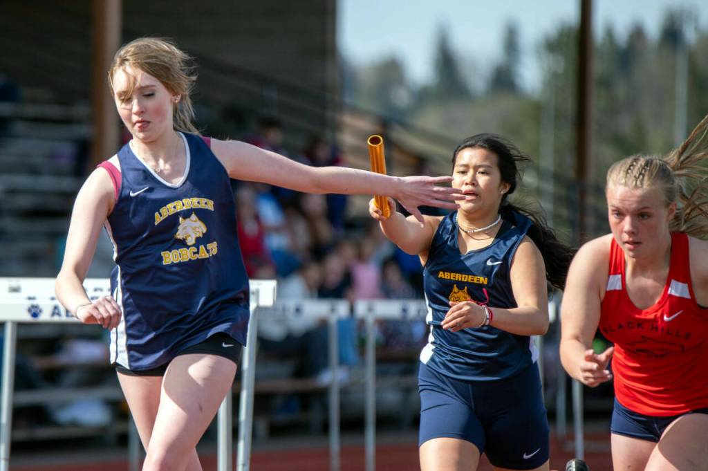 PHOTO BY FOREST WORGUM Aberdeens Mylee Tran, second from right, hands the baton to Alyssa Caskey during the girls 4x200-meter relay on Wednesday in Aberdeen.