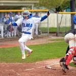 RYAN SPARKS | THE DAILY WORLD Elmas Ethan Camus (22) leaps away from Tenino catcher Austin Gonia to score a run during the Eagles 9-8 win on Friday at Vessey Field in Montesano.