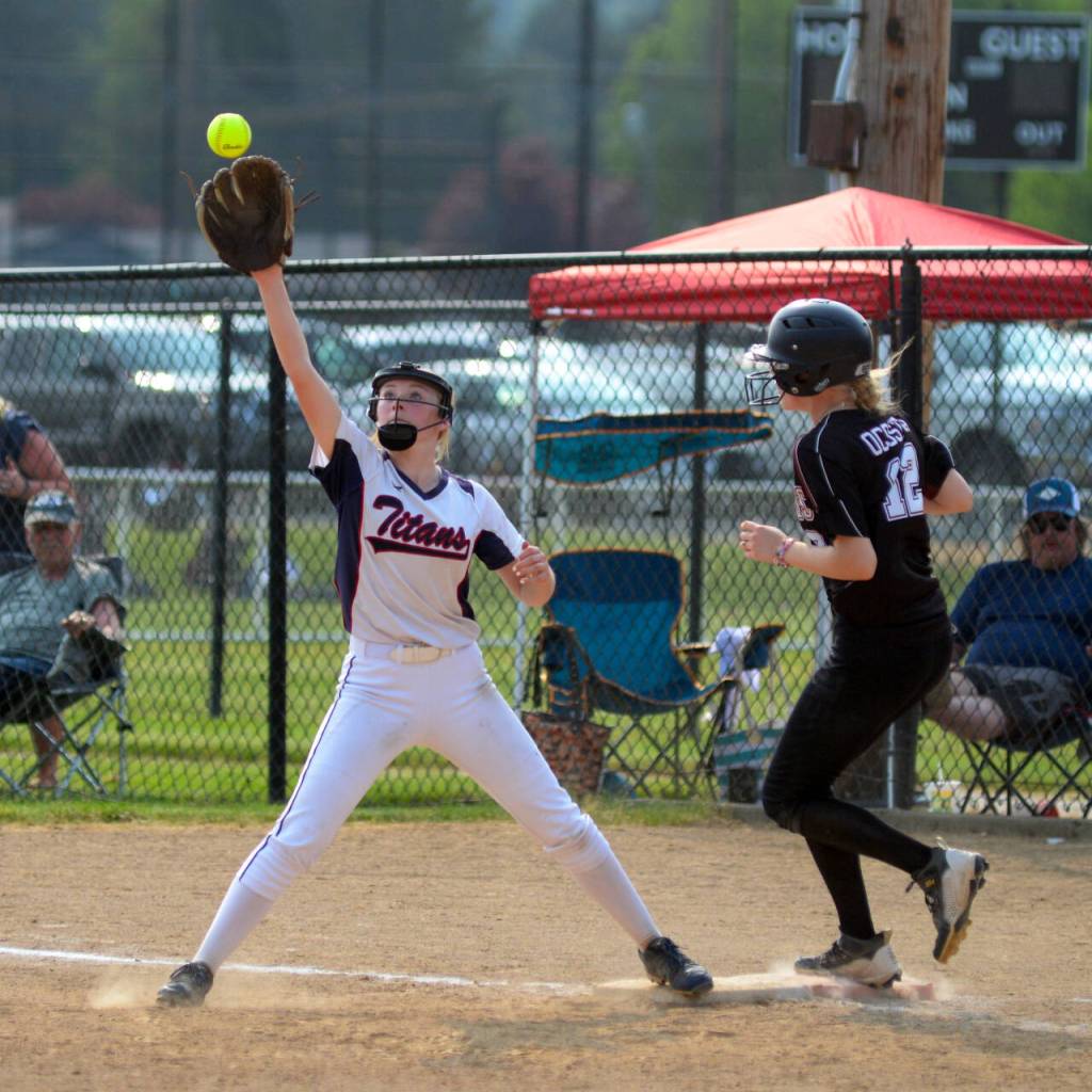 RYAN SPARKS / THE DAILY WORLD Ocostas Samantha Schlegel (12) beats the throw to first during the Wildcats 2-0 win over Pe Ell-Willapa Valley in the 2B District 4 semifinals on Wednesday in Centralia. PWV first baseman Jillian Hodel defends on the play.