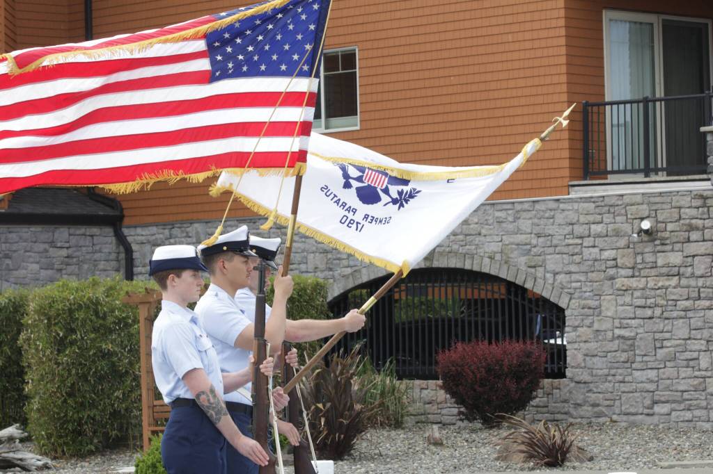 A steady sea breeze unfurls the colors during a ceremony remembering and honoring those claimed by the sea in Westport on May 28. (Michael S. Lockett / The Daily World)
