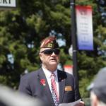 Veterans of Foreign Wars Post 224 Chaplain Jim Daly speaks during the dedication ceremony for banners honoring the war dead of the county in Cosmopolis, one visible behind Daly, on Memorial Day, May 29. (Michael S. Lockett / The Daily World)