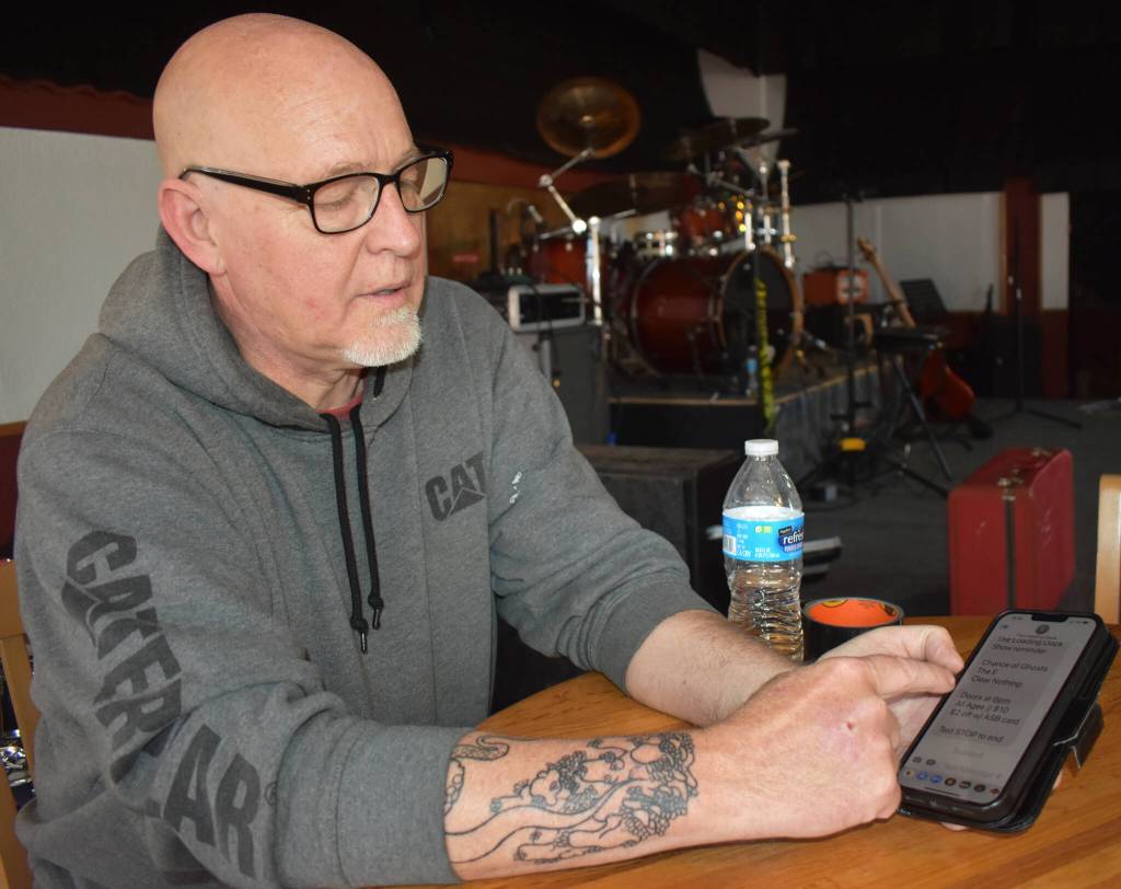 Matthew N. Wells / The Daily World
Larry Cowles, who rents The Loading Dock  202 E. Wishkah St., shows how easy it is to stay plugged in to what the venue hosts each month. Just text GHMUSIC to 855-642-7684 to stay informed. Cowles said after texting the number to opt in to the venue updates, people receive reminders so they never lose track of when the next live show happens. Admission to the shows is $10 and outside the money that goes to rent the venue, everything else goes to the bands that play there.