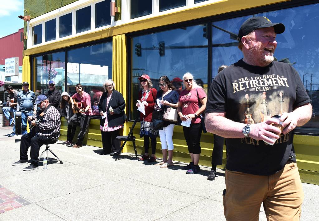 Matthew N. Wells / The Daily World
A man stands smiling amongst part of the large, happy group who assembled to celebrate World Music Day. Musicians gathered Wednesday to play music and at the end of the approximate hour-and-a-half event, they joined each other to play a unique rendition of Come As You Are, a Kurt Cobain classic from Nirvanas Nevermind album.