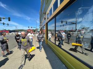 Matthew N. Wells / The Daily World
Phil Fill Slep, holding a yellow horn, leads a small tour through Aberdeen that provided information about one of the citys most famous sons, Kurt Cobain. The tour wound down as Slep showed his guests the Side One Building, which will soon be home to The Tribute Gallery and The Green Room. If you look close, you can see a Charles Peterson archival photo of Cobain crowdsurfing.