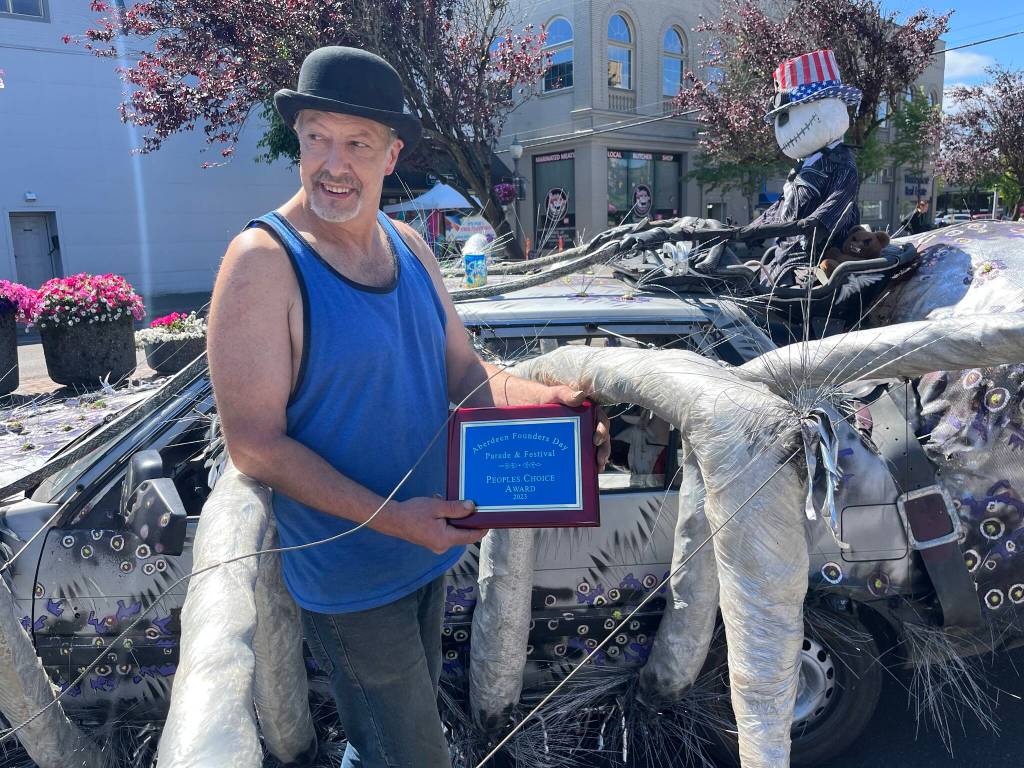 Kevin Lorentzen, of Raymond, looks at the happy families who were taking photos of his award-winning Spider car. No stranger to winning with his art, Lorentzen described how he makes the most out of the near 40-year-old car in order to get fun and incredible reactions out of children and adults alike. (Matthew N. Wells / The Daily World)