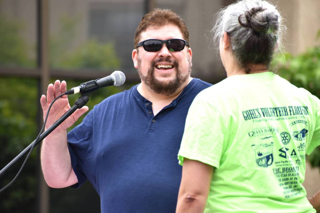 Matthew N. Wells / The Daily World
Phil Luceman, emcee for the 10th anniversary of Aberdeen Founders Day Parade, shares a laugh with Karen Rowe. Rowe, with her husband Ryan and Tawni Andrews, takes point in getting the parade going, as they do every year in July.